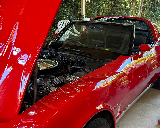 Red classic car with its bonnet open
